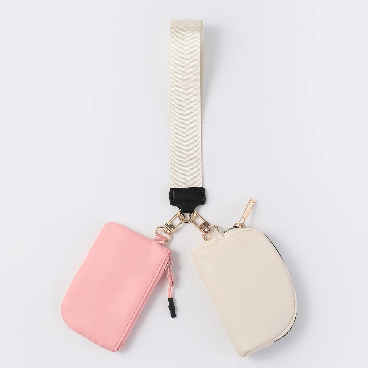 Pink and white nylon dual zip closure wristlet wallet with an adjustable strap for carrying cards and keys on the go.