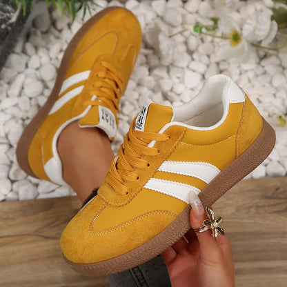 Mustard yellow leather slip-on sneakers with white stripes, suede detailing, and brown rubber soles for daily wear.