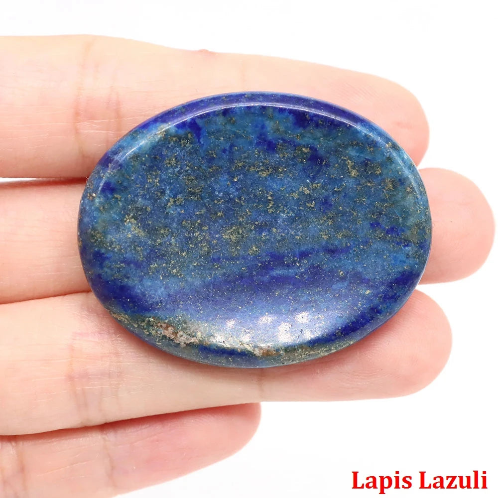 Hand-carved oval blue lapis lazuli palm stone with gold flecks for home decor meditation.