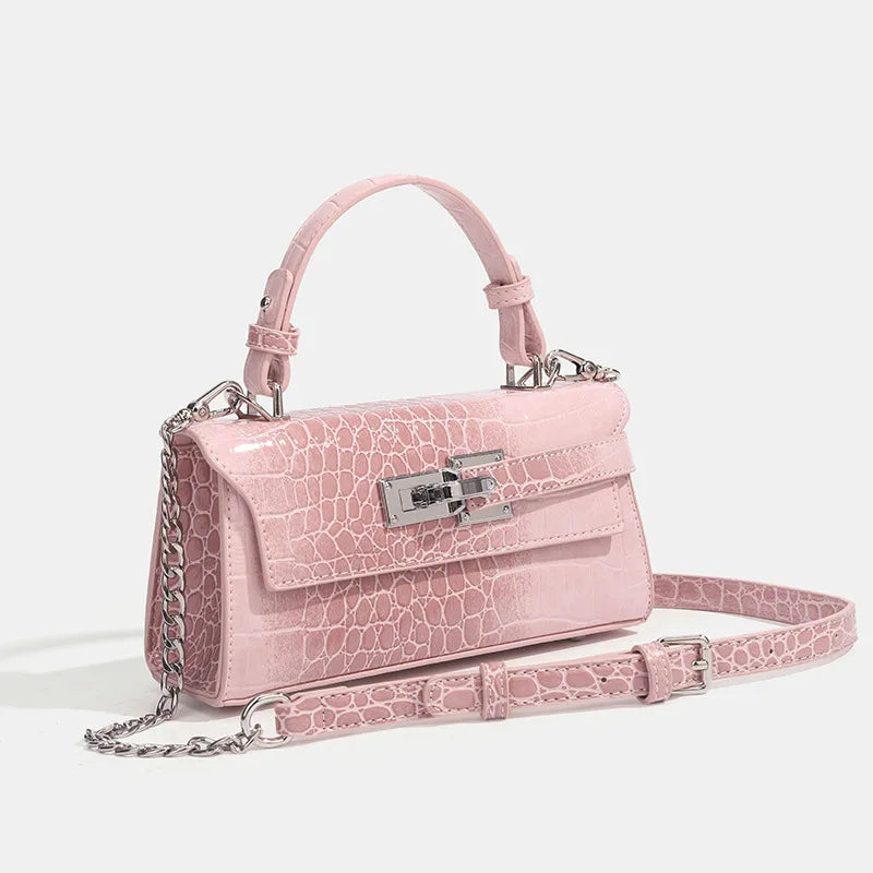Pink faux leather structured crossbody bag with silver hardware, adjustable strap, and zip closure for daily errands.