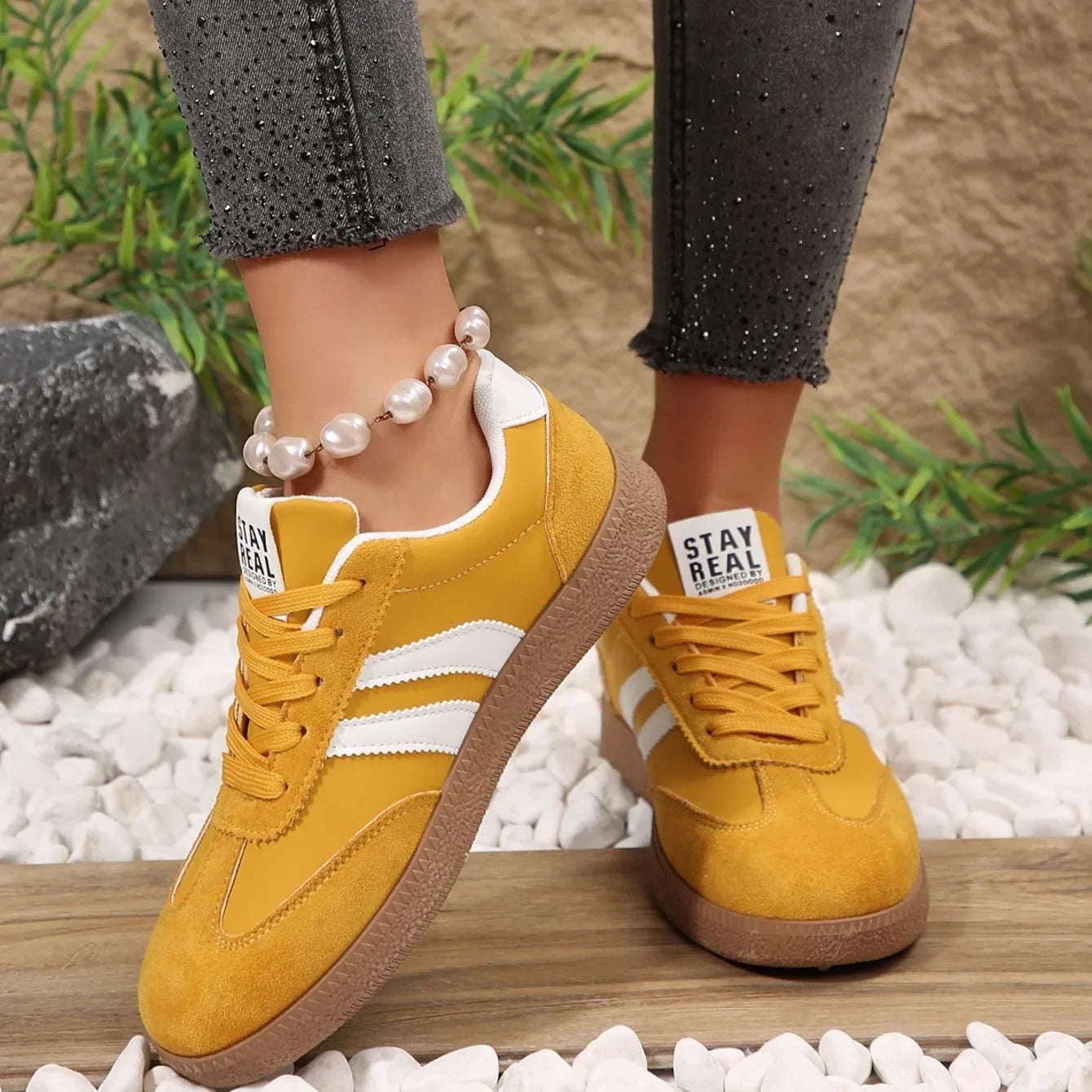 Yellow suede and leather sneakers with white stripes and gum soles, these slip-on shoes are comfortable for daily wear.