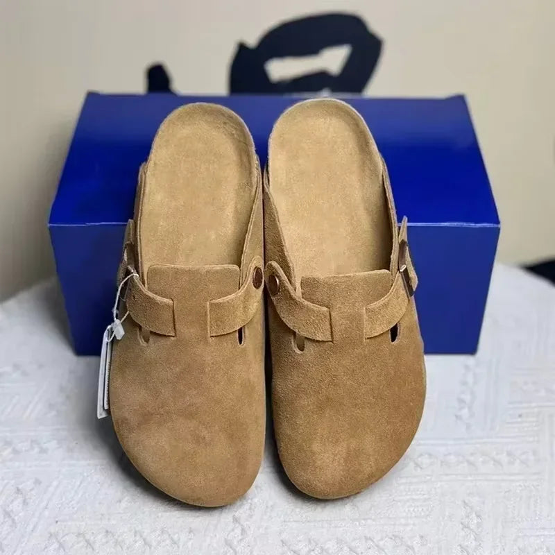 Tan suede mules featuring a buckled strap design and non-slip sole for comfortable beach wear.