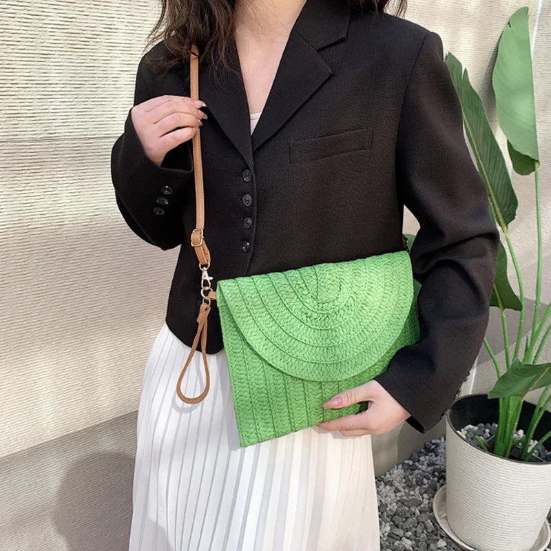 Bright green woven envelope crossbody bag with an adjustable strap, used for carrying beach essentials.