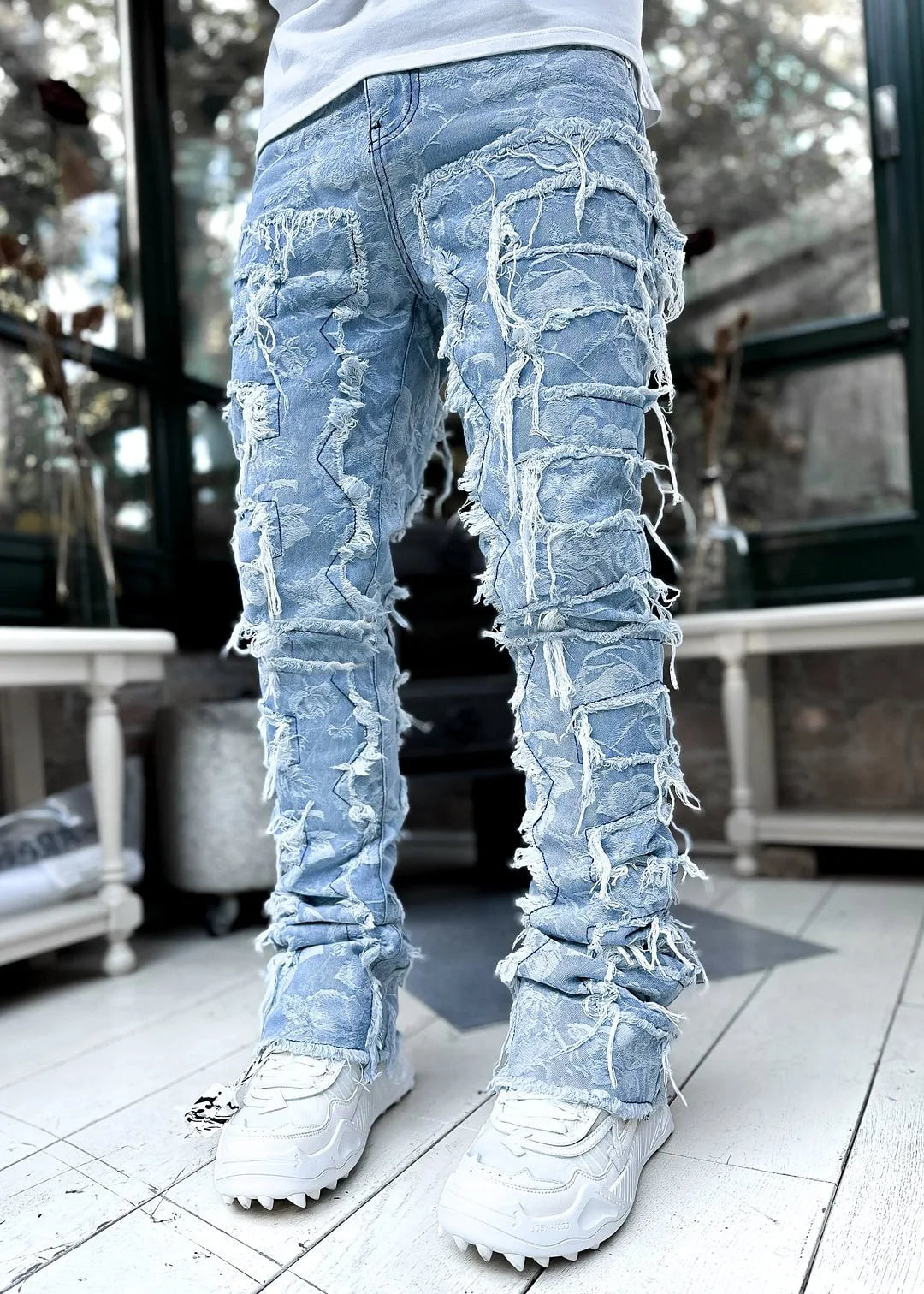 Light blue floral woven patchwork jeans with distressed frayed tassel details for casual streetwear outfits.