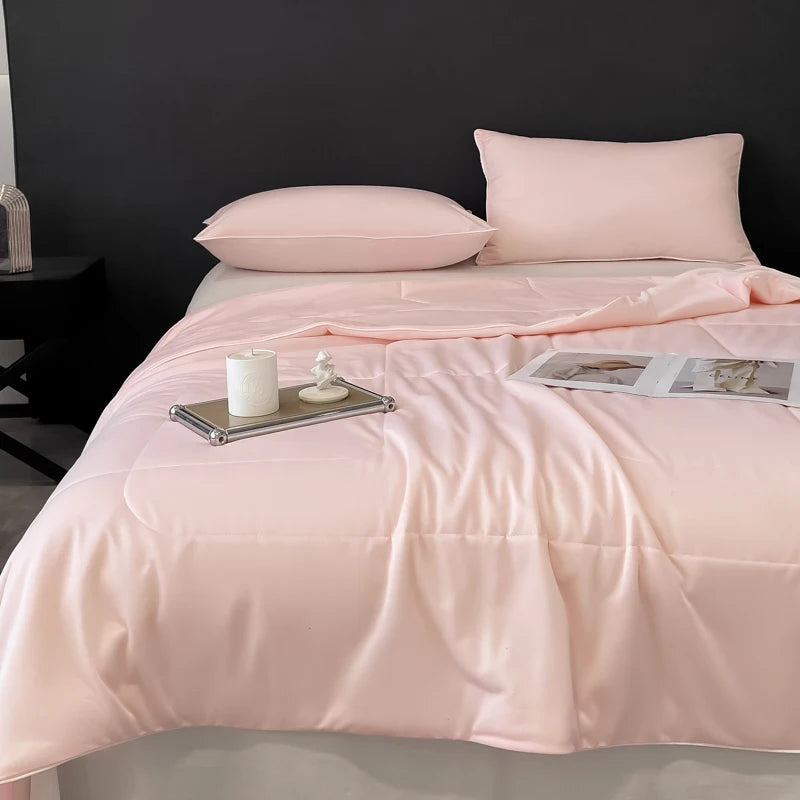 Light pink, smooth cooling comforter with bedding and bath material for comfortable sleep.