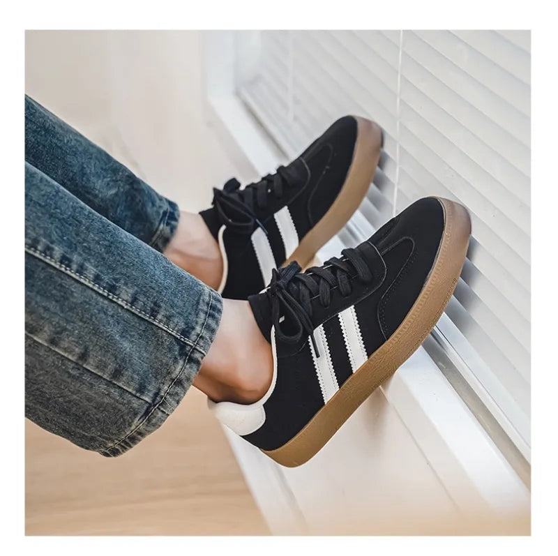 Black canvas sneakers with white stripes and brown soles, a breathable casual training shoe for daily wear.