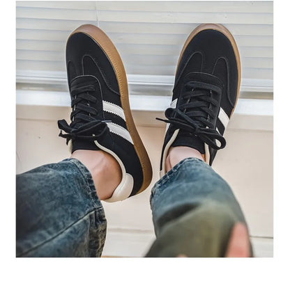 Black canvas sneakers with white stripes and gum soles. Breathable casual training shoes for daily wear.