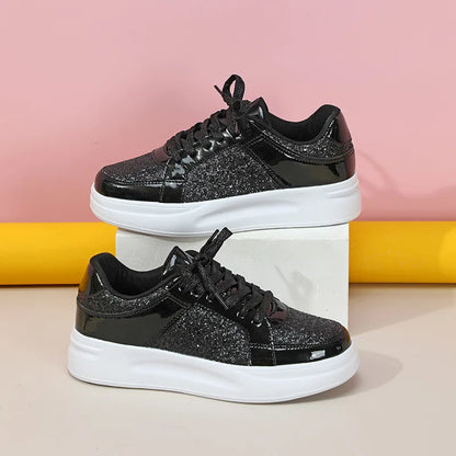 Black lace-up casual sneakers with sparkly glitter panels, patent leather accents, and thick white platform soles.
