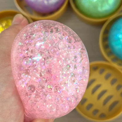 Clear pink squishy fidget toy filled with sparkly beads in a mini plastic hot pot for sensory stress relief.