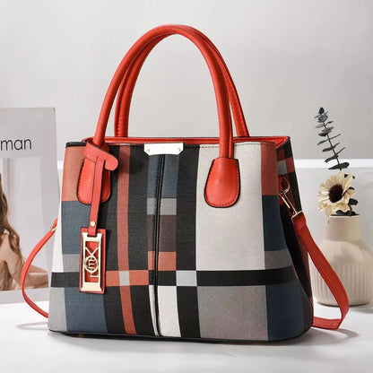 Red, black, and white plaid structured tote bag with zip closure and adjustable strap for everyday use.