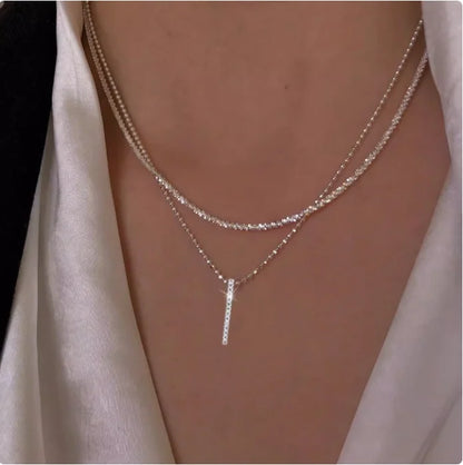 Women's gold-tone layered chain necklace with pendant detail