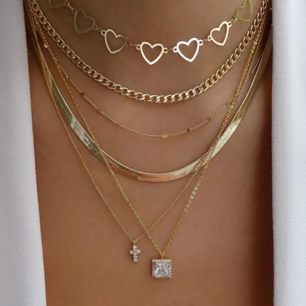 Layered necklace set featuring crystal pendants, rhinestones, chains, and charms