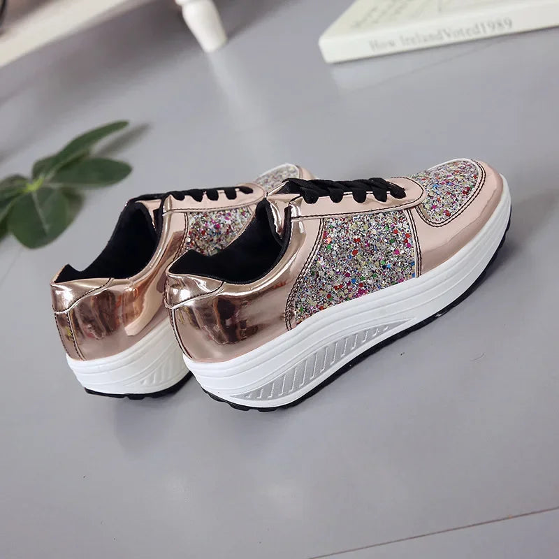 Rose gold metallic sneakers with multicolored glitter panels, black laces, and thick white platform soles.