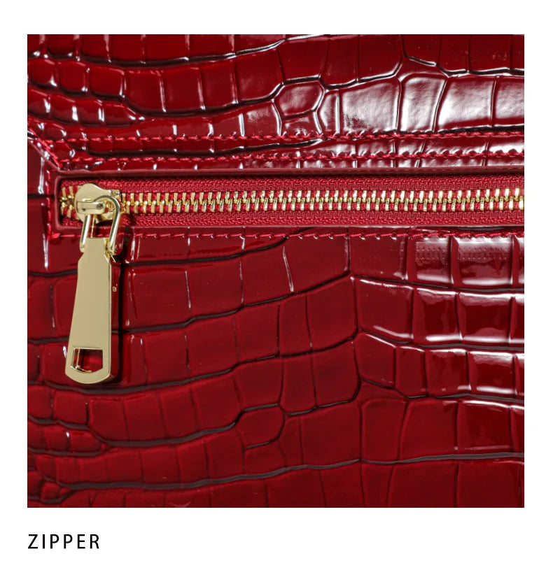 Red lacquer cowhide handbag with crocodile pattern and gold zipper detail.
