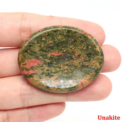 Polished, oval unakite stone with green and pink mottling as home decor for meditation.