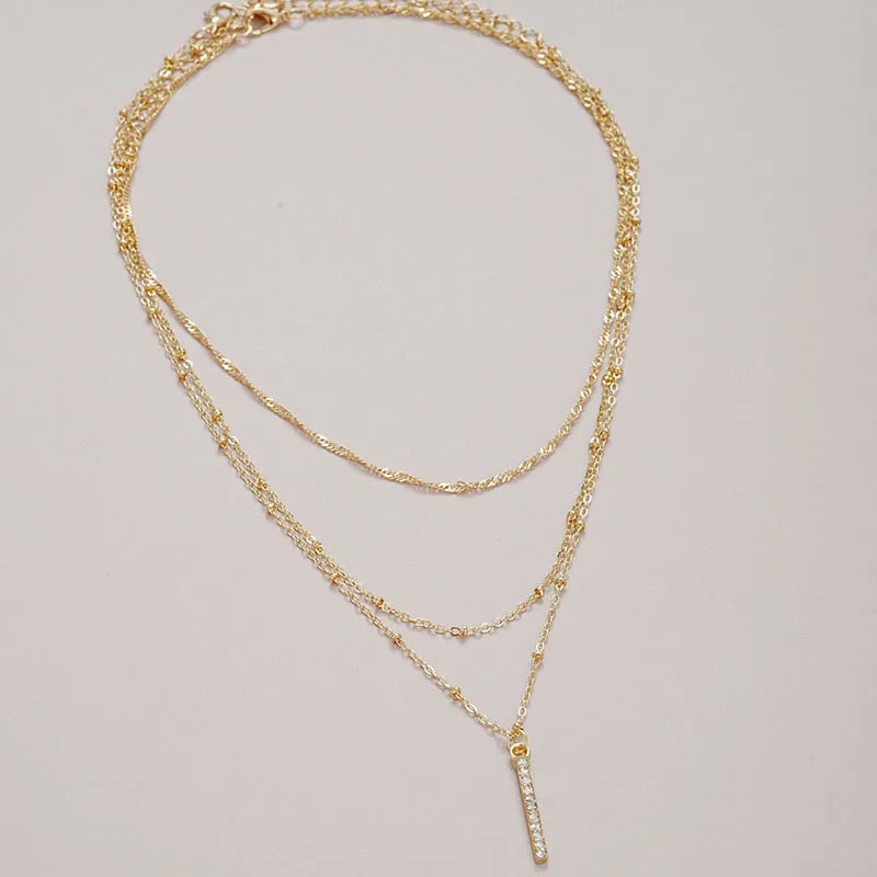 Women's gold-tone layered chain necklace with pendant detail