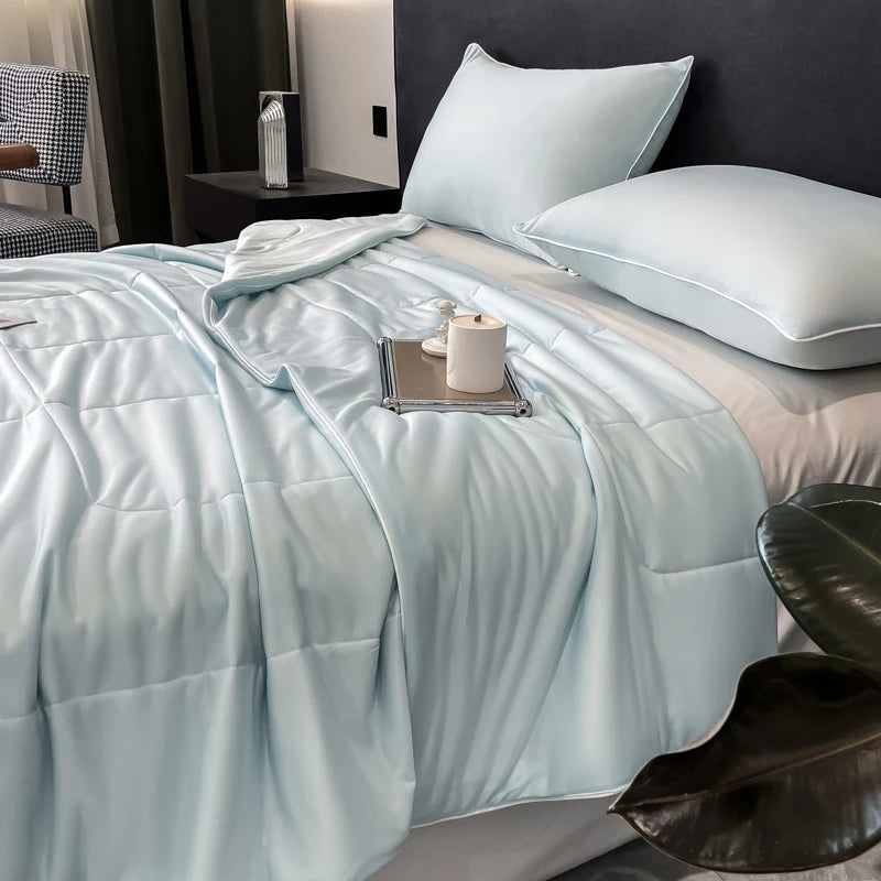 Light blue cooling comforter with a smooth, breathable finish on a bed for hot sleepers.