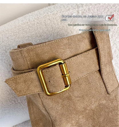 Brown suede boot shaft with a decorative strap and a square gold-tone metal buckle.