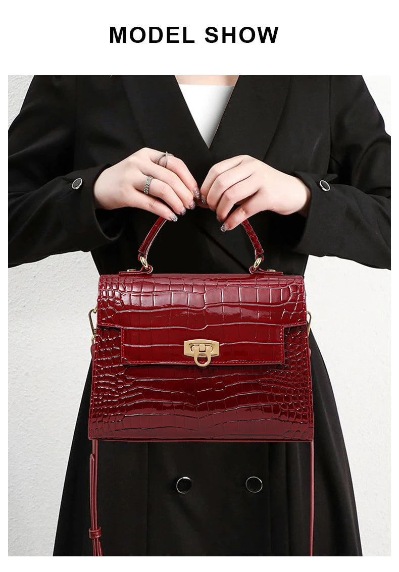 Red glossy crocodile-pattern leather handbag with a top handle and gold clasp.