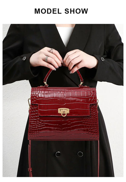 Red glossy crocodile-pattern leather handbag with a top handle and gold clasp.