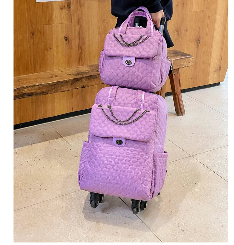 Purple quilted nylon rolling luggage set with chain accent, front pocket, twist-lock closure, and dual wheels.