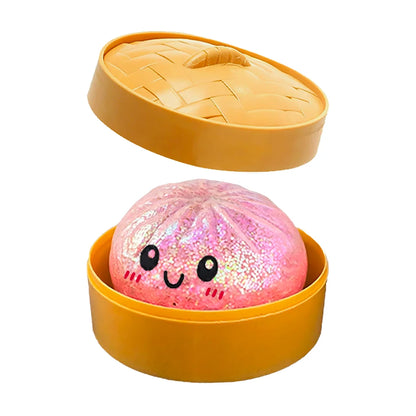 Pink glittery dumpling squishy fidget toy inside a yellow plastic steamer basket for sensory play.