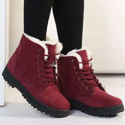 Red suede lace-up ankle boots with white faux fur lining and black lug soles.