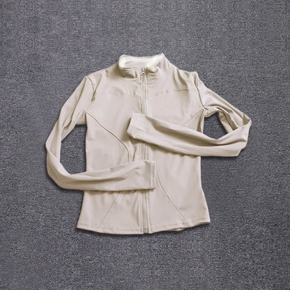 Beige long-sleeve polyester sport jacket with a fitted design, zip closure, and seams for gym training and yoga.