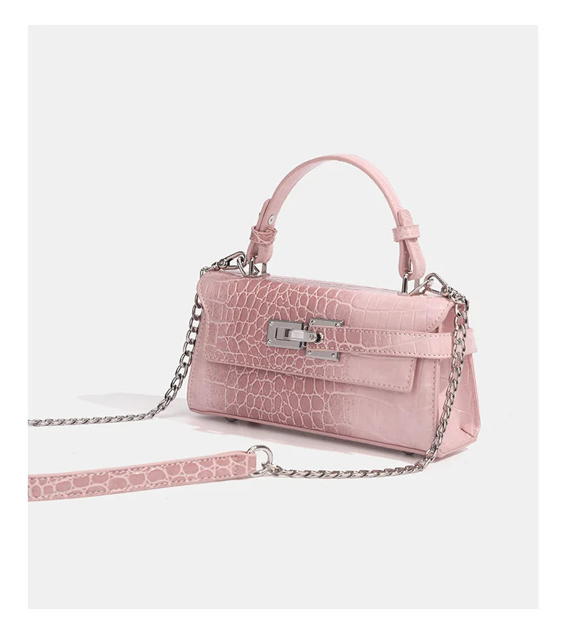 Pink crocodile-embossed faux leather crossbody bag with chain strap and metal lock closure for daily outings.
