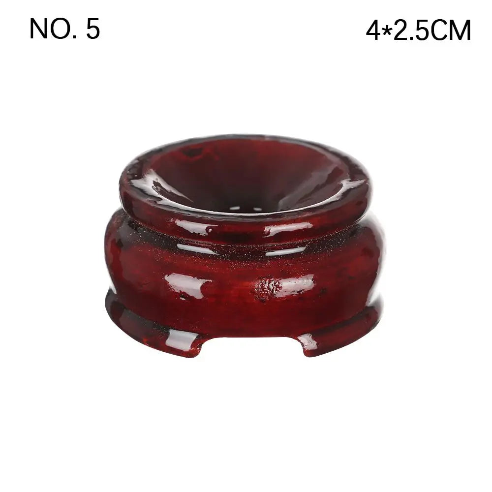 Dark reddish-brown polished wooden crystal ball stand with a rounded, footed design and a top indentation.