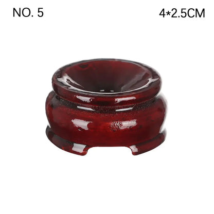 Dark reddish-brown polished wooden crystal ball stand with a rounded, footed design and a top indentation.