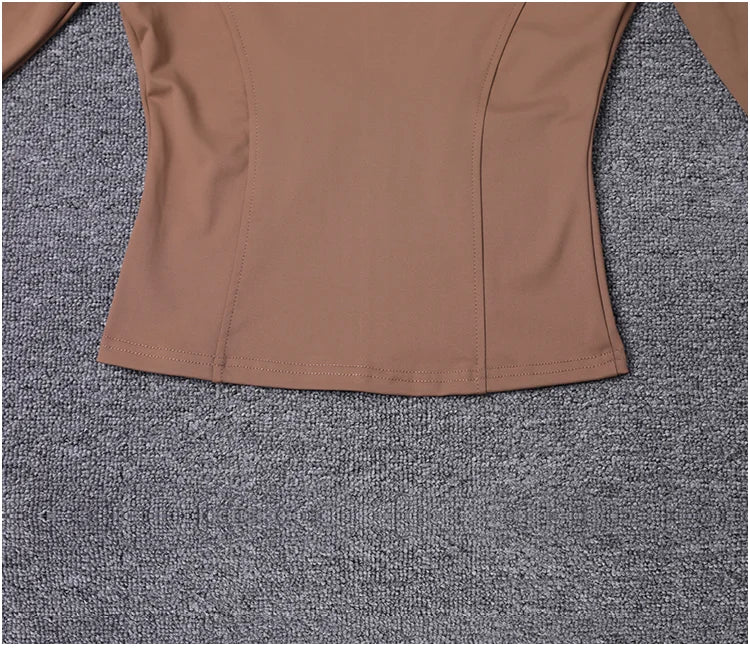 Tan polyester fitted sport jacket with seams for gym training and yoga.