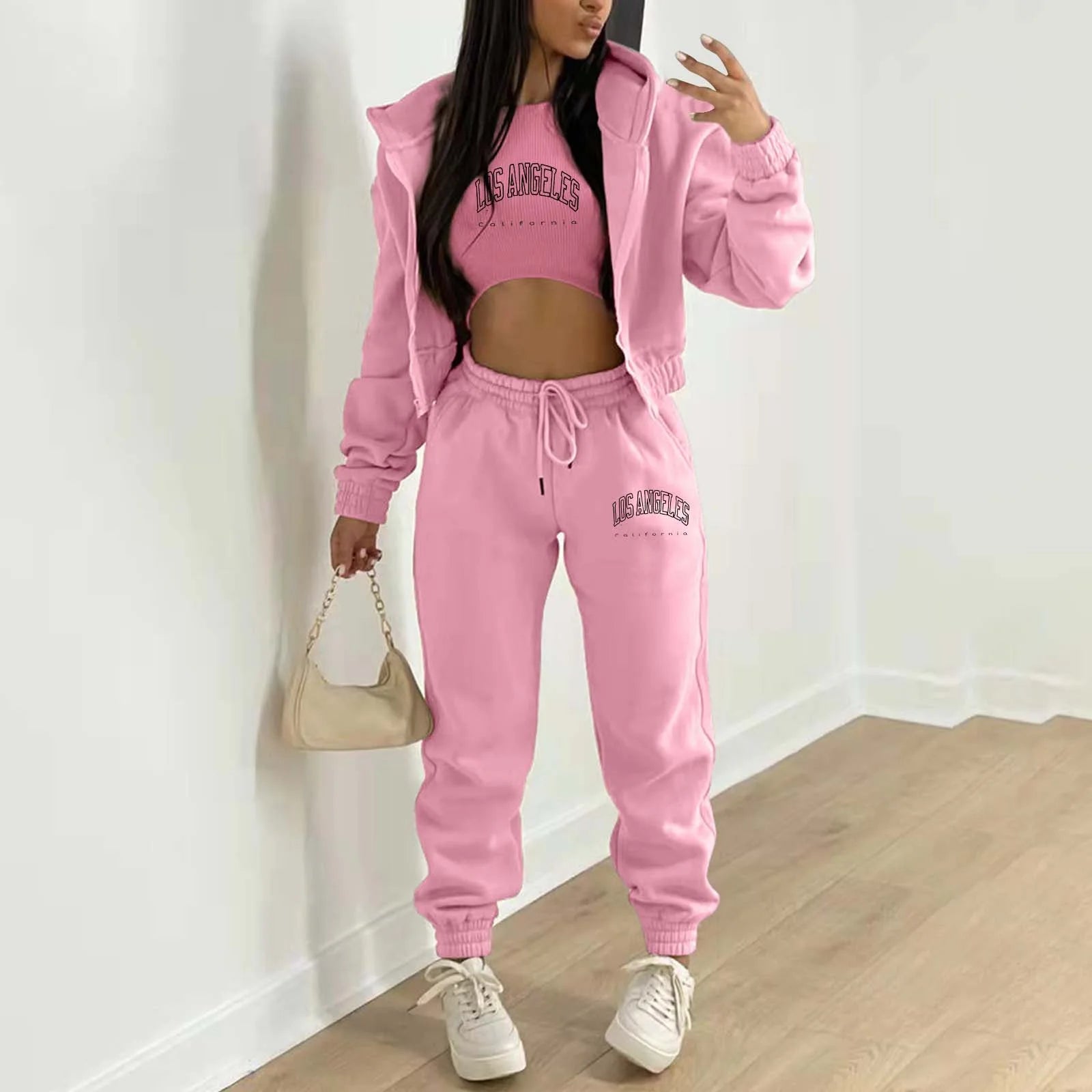 Pink knit sweater set with Los Angeles letter print, hoodie, and drawstring joggers for a relaxed loungewear look.