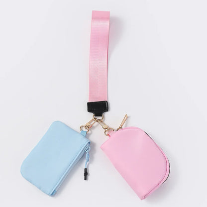 Blue and pink nylon dual pouch wristlet with zip closure for holding cards and coins on the go.