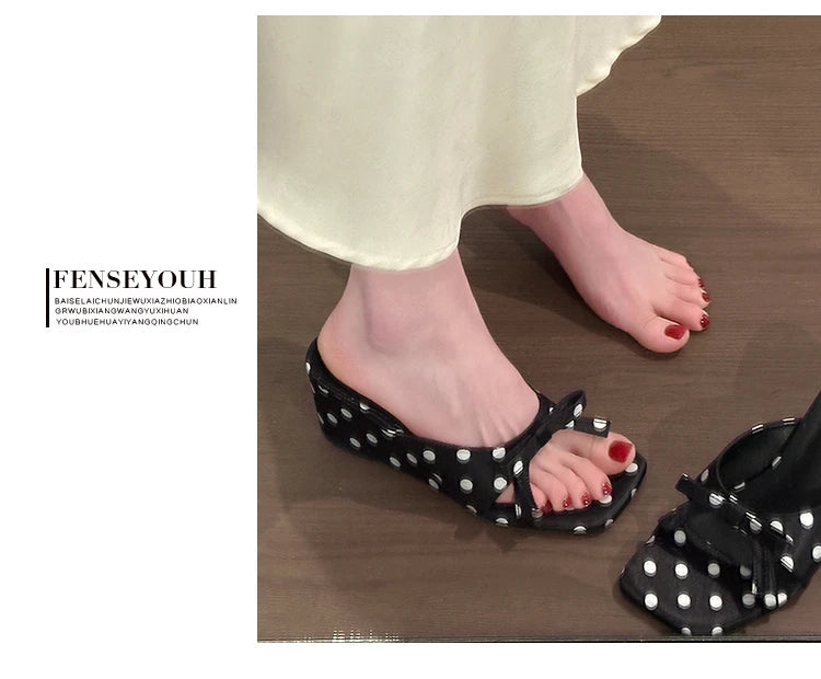 Black polka dot wedge sandals with bow detail and cushioned insole for comfortable casual wear.