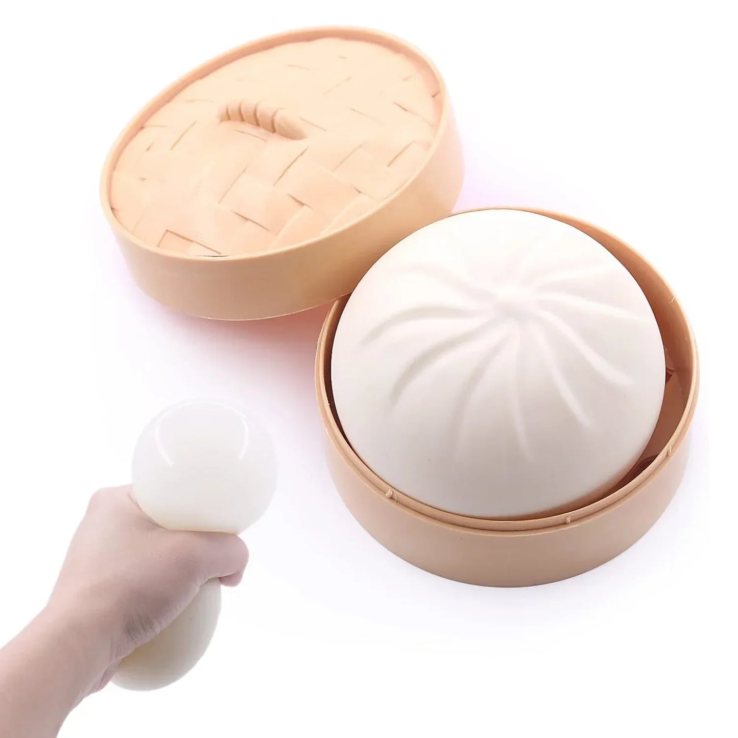 Soft white squishy dumpling toy in a tan plastic steamer basket, a sensory fidget toy set for stress relief.