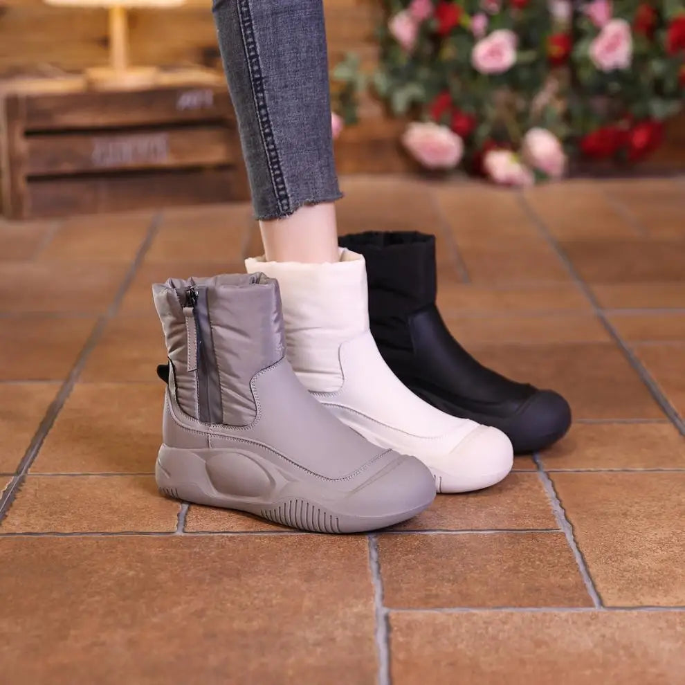 Gray, white, and black short winter boots with side zippers, quilted shafts, and thick rubber soles.