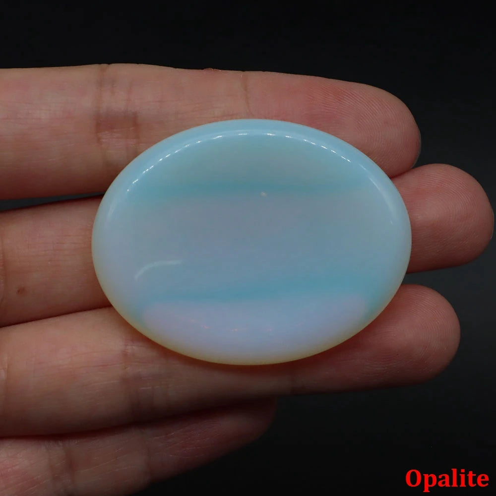 Smooth, iridescent blue opalite palm stone held in a hand for meditation home decor.
