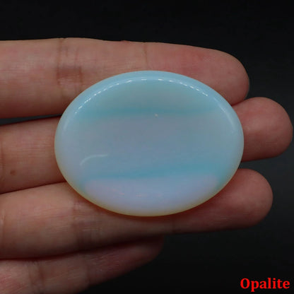 Smooth, oval, translucent blue opalite palm stone held in hand for home decor meditation.