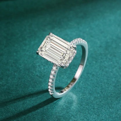 Silver ring with a large emerald-cut center stone and pave-set band.