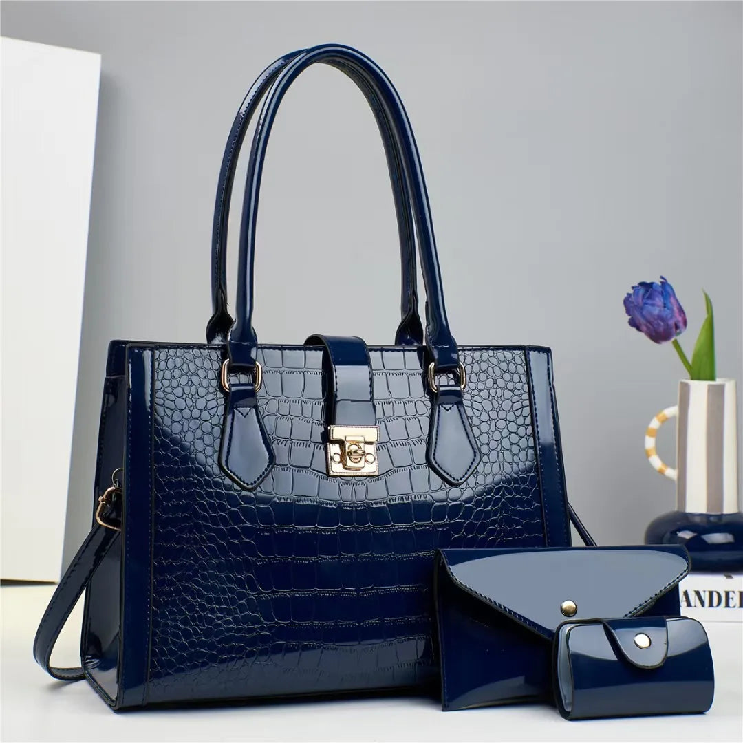 Dark blue patent leather crocodile-pattern handbag set with structured top handles, clasp, and two matching wallets.