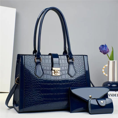 Dark blue patent leather crocodile-pattern handbag set with structured top handles, clasp, and two matching wallets.
