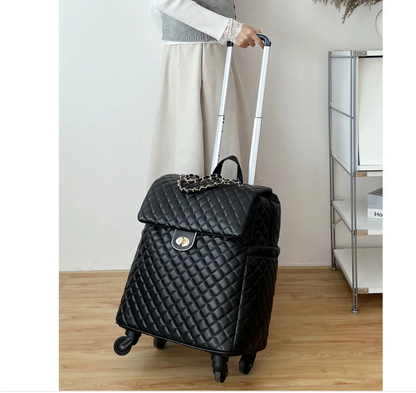 Black quilted faux leather travel suitcase with gold twist-lock closure, chain accent, and rolling wheels.