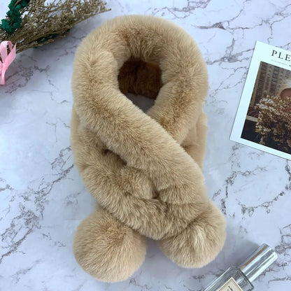 Beige plush faux fur cross scarf with two pom-poms at the ends.