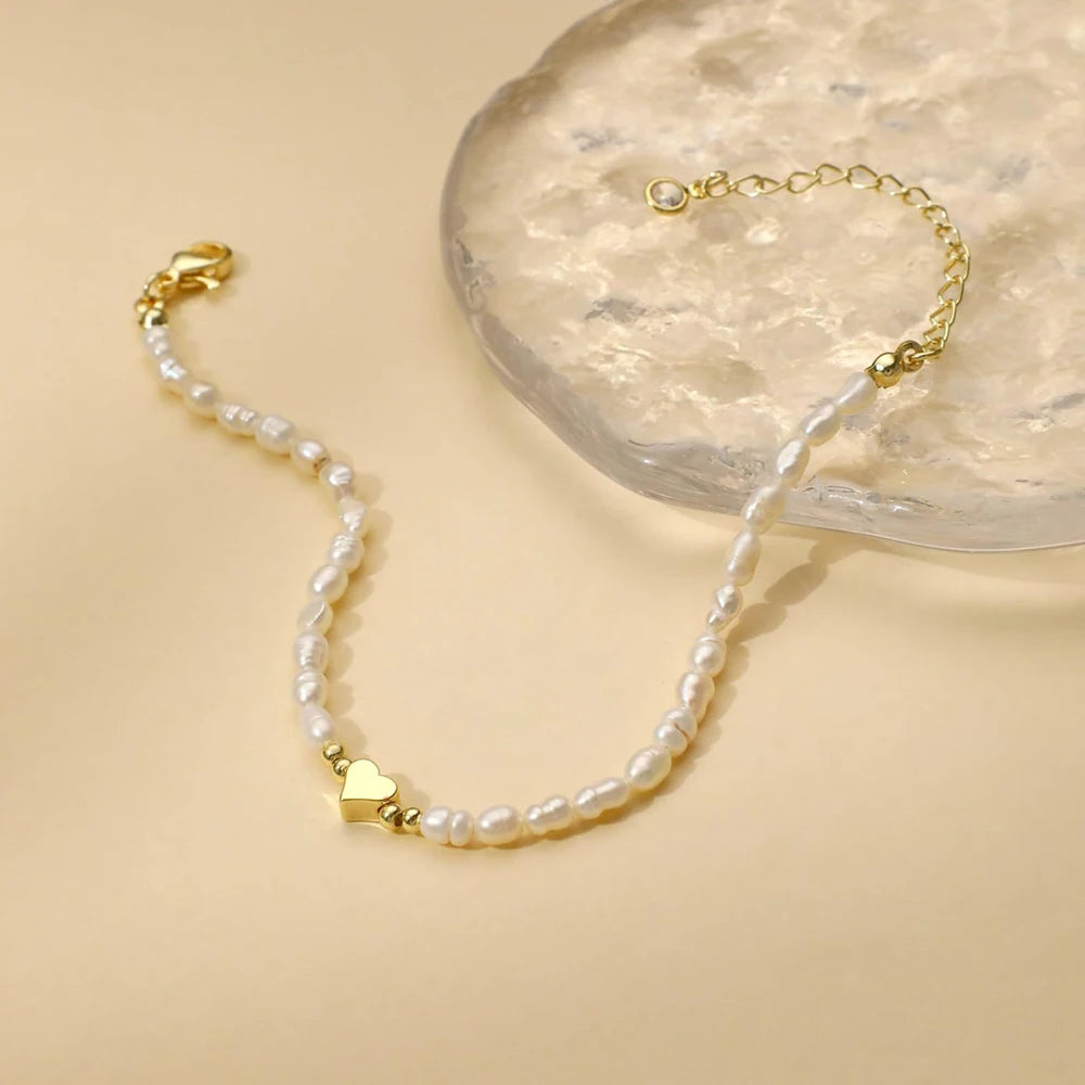 Women's pearl bracelet with heart and evil eye charms