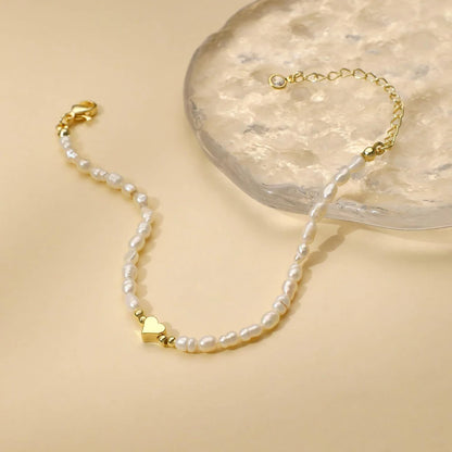 Women's pearl bracelet with heart and evil eye charms