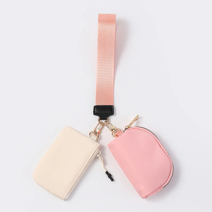 Pink and cream nylon dual pouch wristlet wallet with a zip closure for carrying cards and keys while on the go.