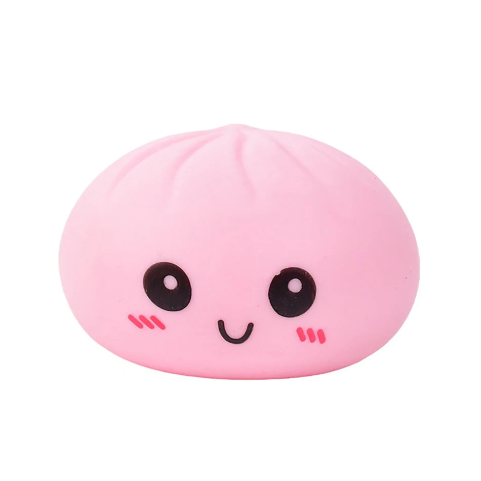 Pink silicone dumpling fidget toy with a smiling face and soft texture for stress relief.
