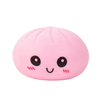 Pink silicone dumpling fidget toy with a smiling face and soft texture for stress relief.