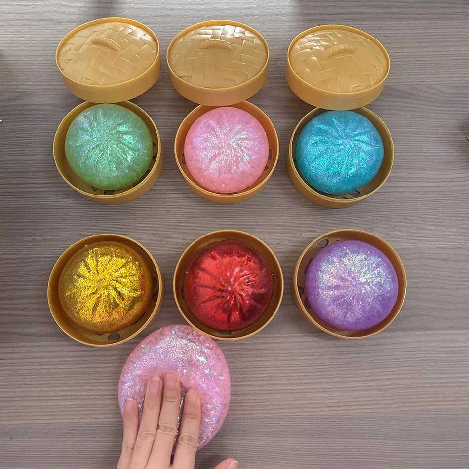 Colorful, glittery dumpling squishy fidget toys in mini bamboo steamer pots for sensory stress relief.